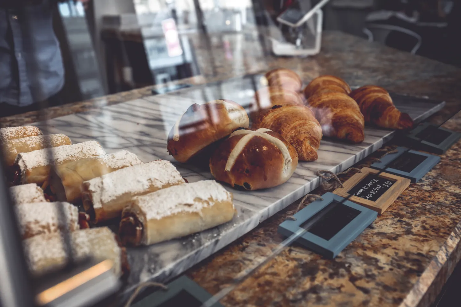 Pastries and rolls in a marble-topped bakery counter