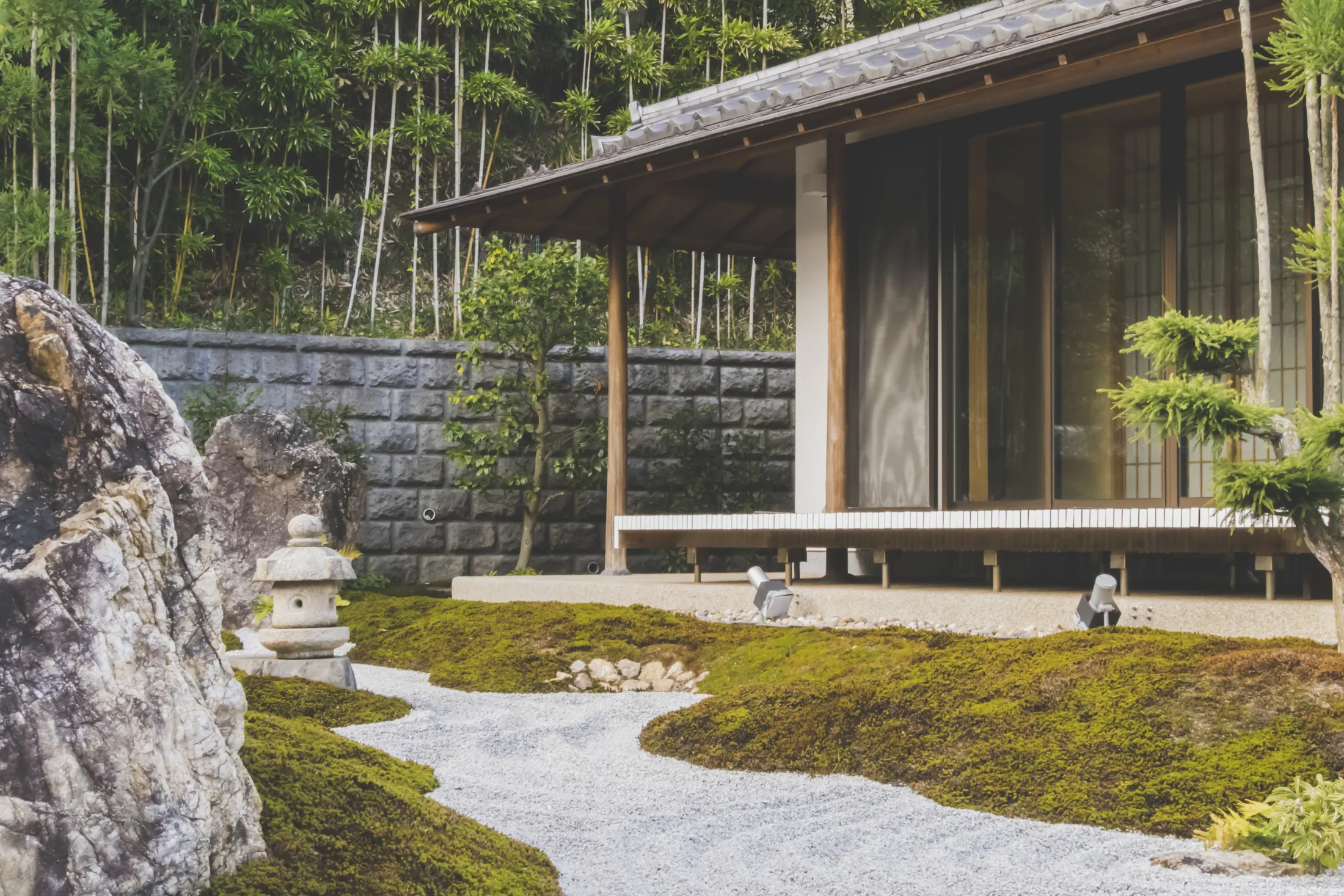 A gravel and moss garden in front of a timber pavilion