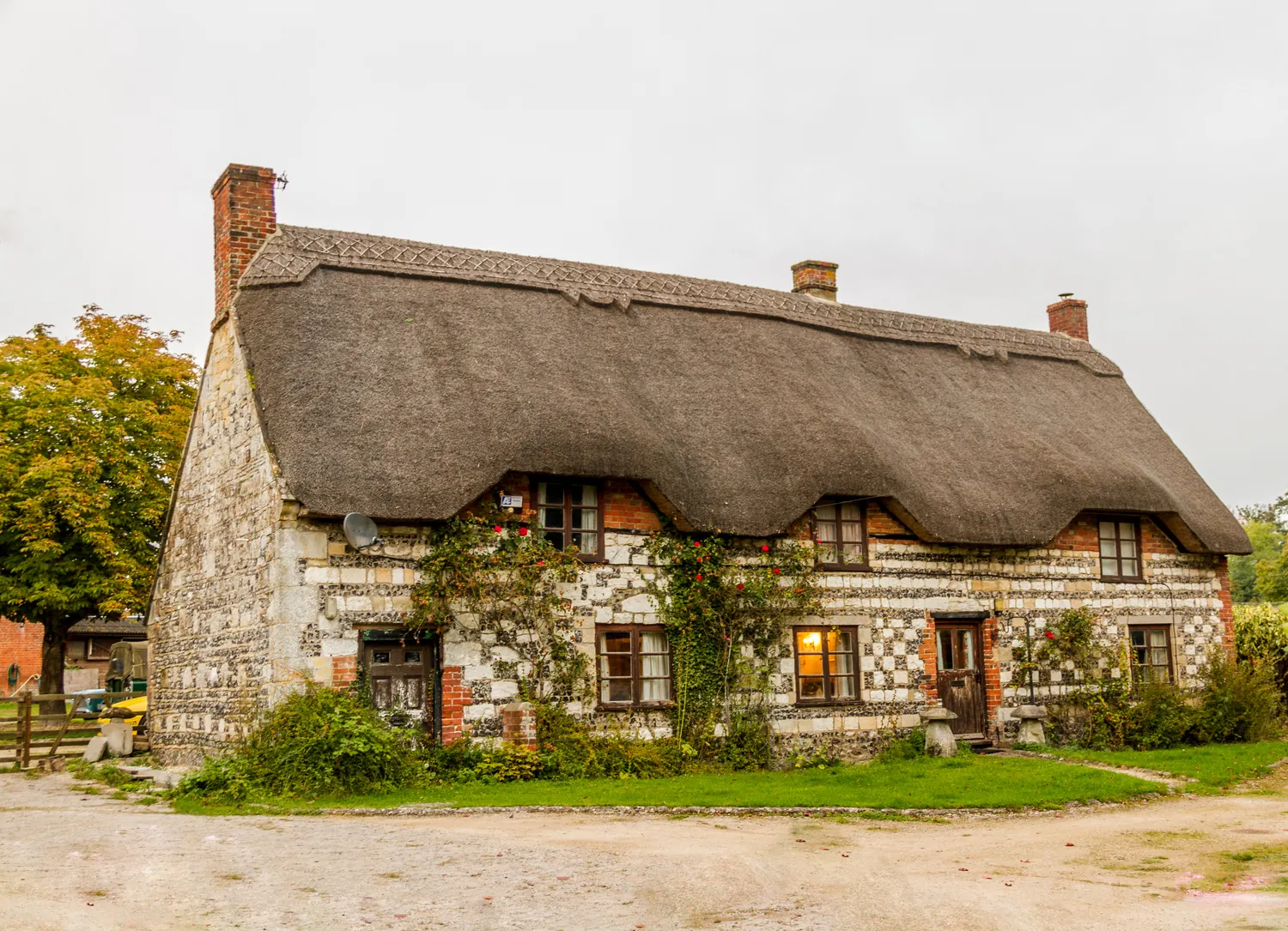 A thatched stone cottage with chimneys